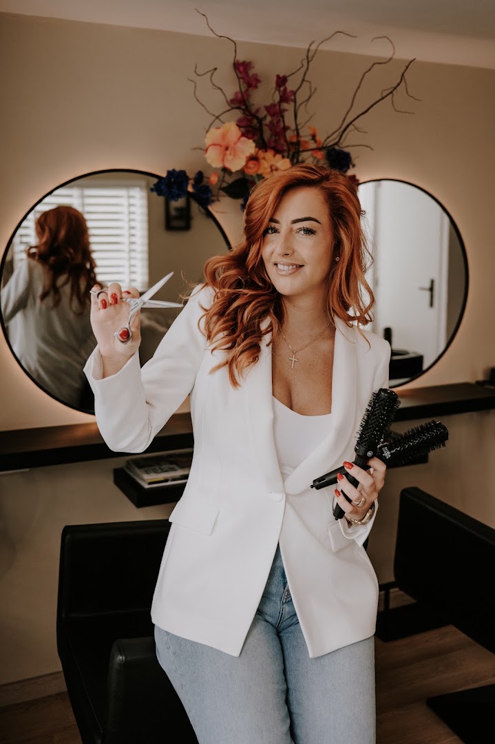 Bo Lokers, kapster van Hair Boutique By Bo, met schaar en föhnborstel in haar salon aan huis